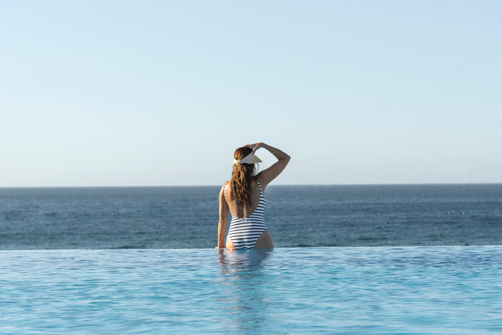 Woman overlooking the ocean from the pool